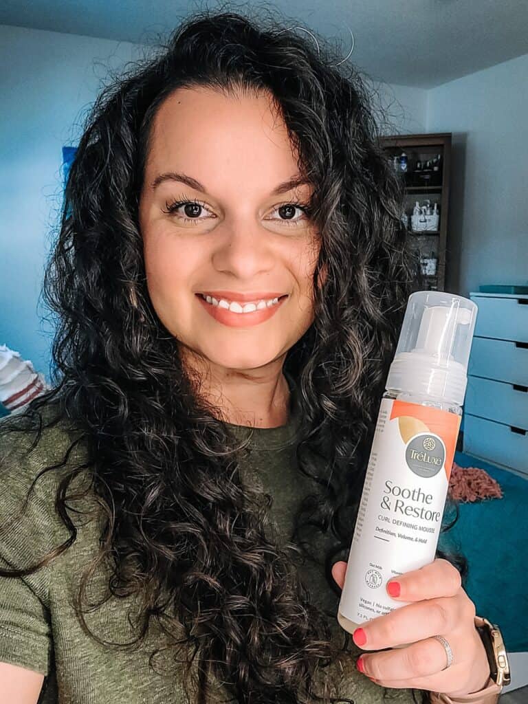 holding up a glycerin free hair product for my curly hair