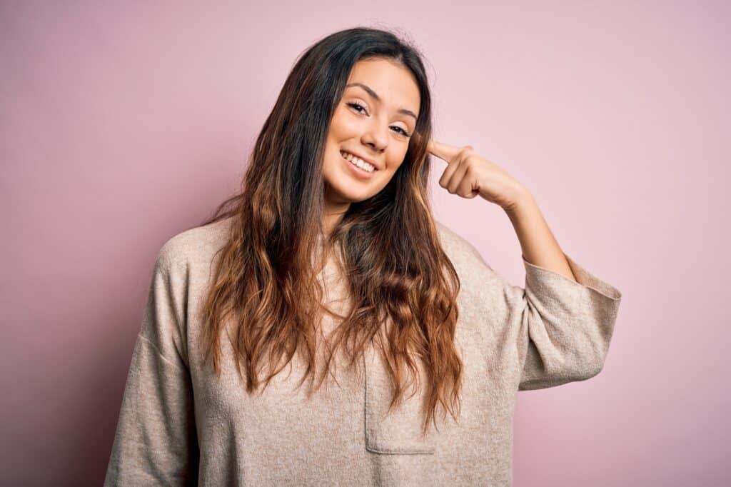 woman with brown 1b hair smiling with head tilted to right