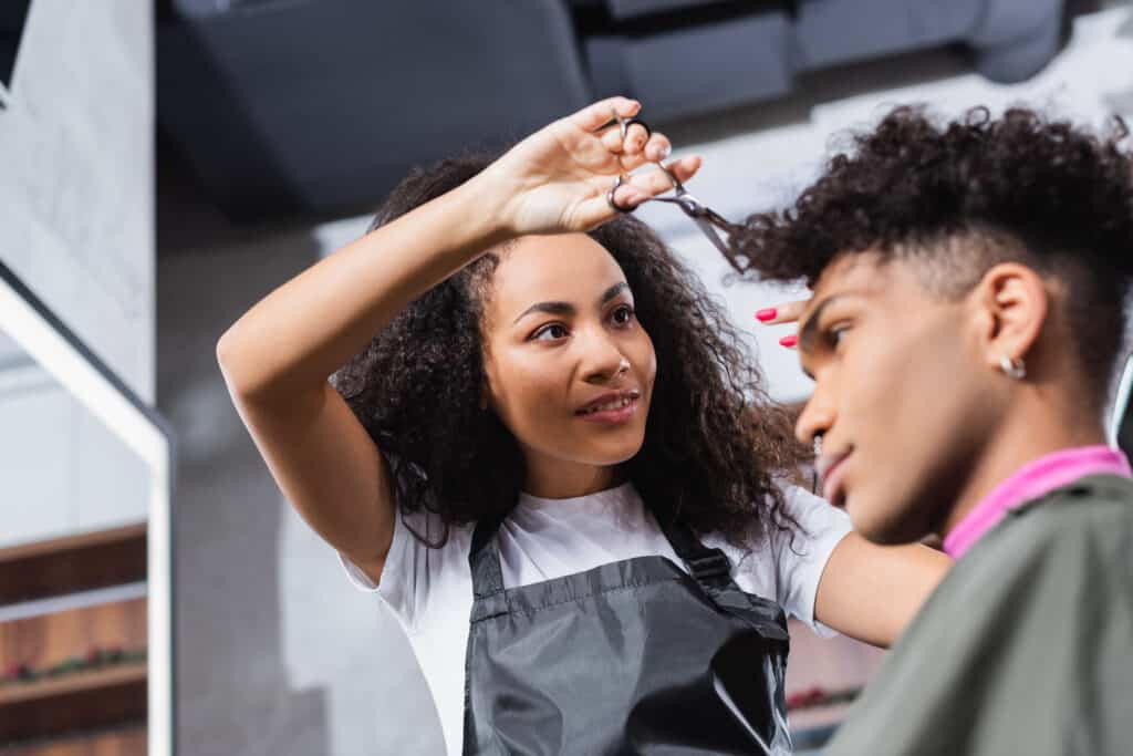 curly hair cutting stylist working