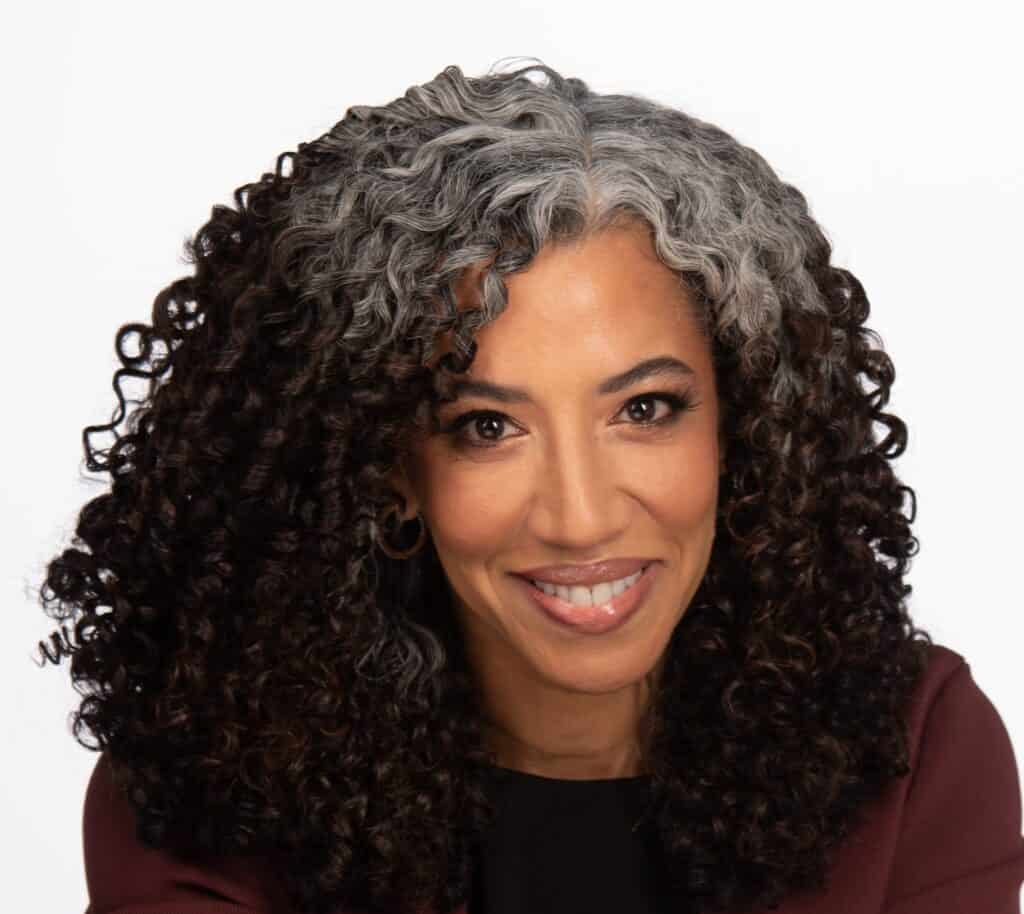 picture of Gabi smiling with defined thick curly hair and silver roots