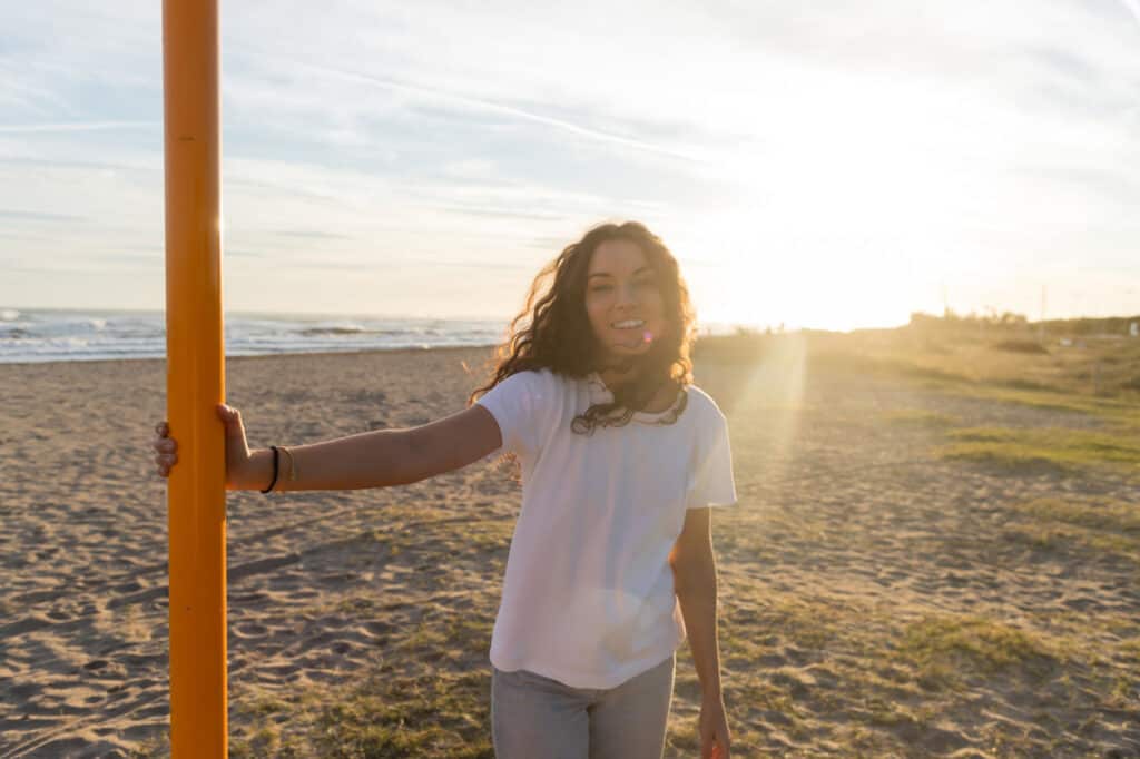 woman with curly hair on the sand in the sun