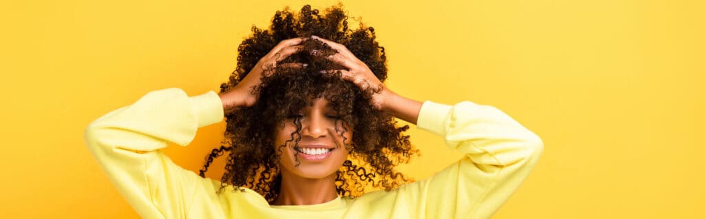 woman with hands in her curly hair